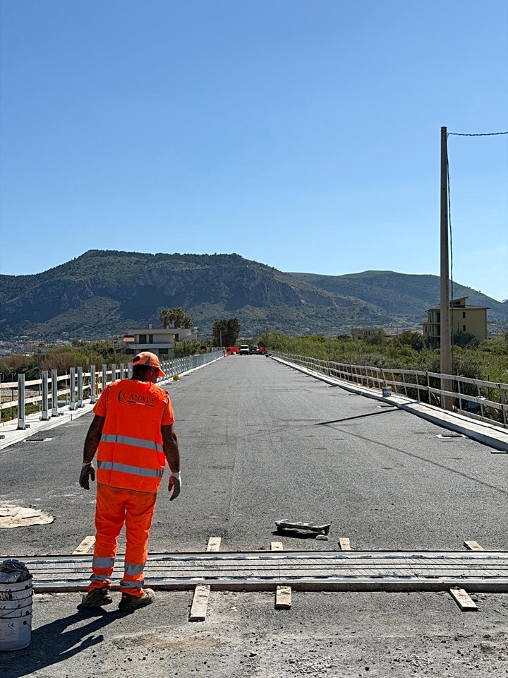 Operaio Canale Costruzioni accanto a un giunto appena posato sul viadotto riasfaltato